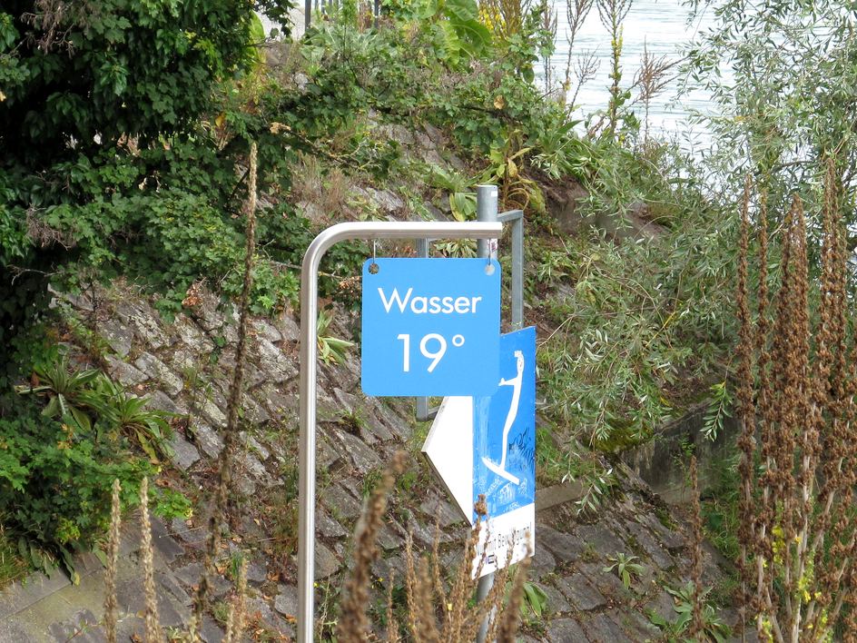 Emailliertes Schild am Rheinufer in Basel mit der Aufschrift «Wasser 19°», daneben der Abgang zum Wasser
